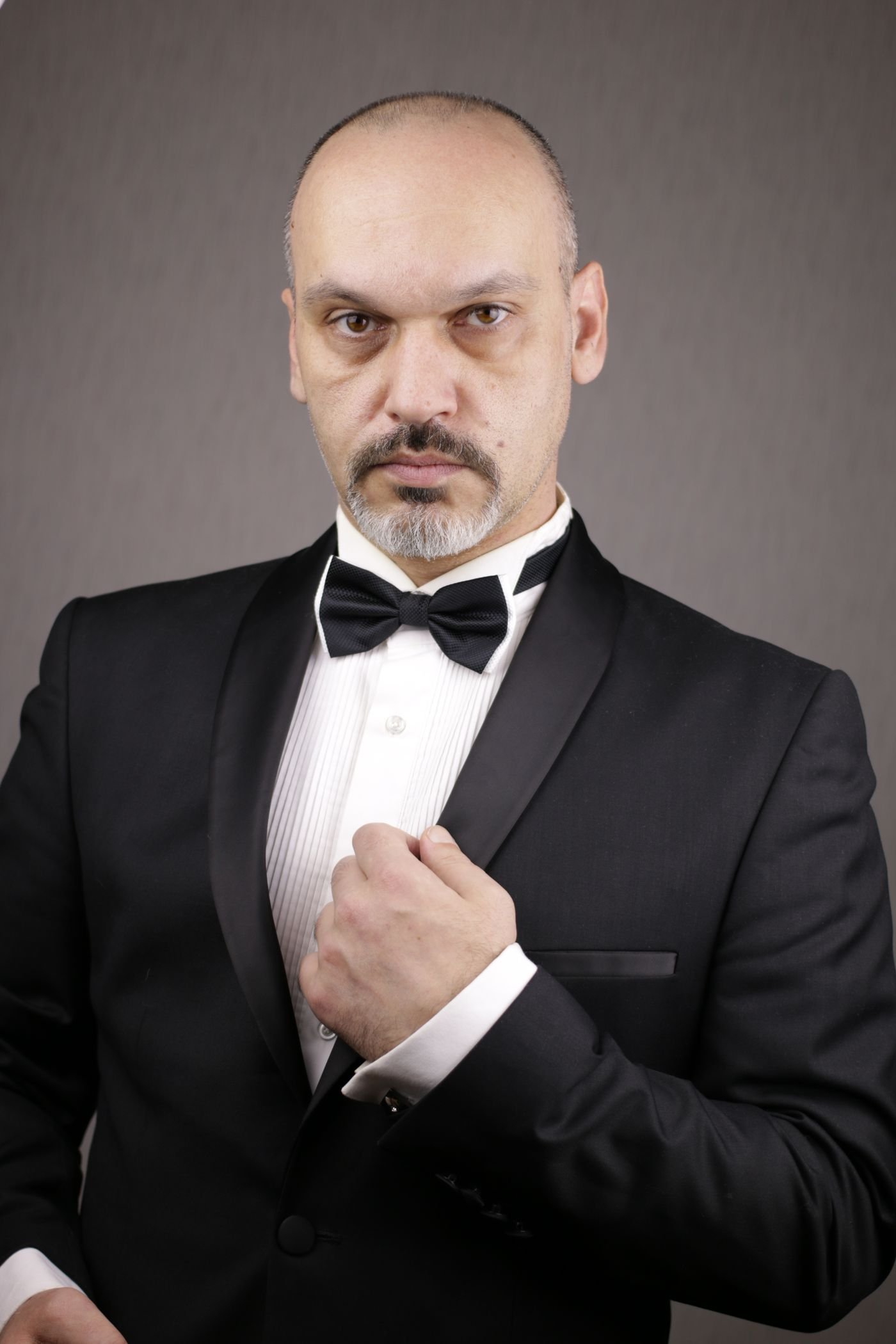 Representative photo of a man in a black formal suit with a bow tie