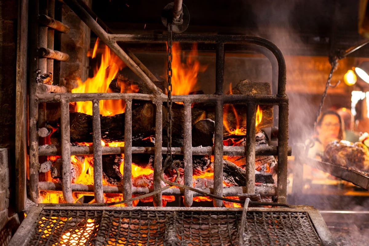 Wood-fired smoker with open flame used to smoke meat at Boss Bully BBQ