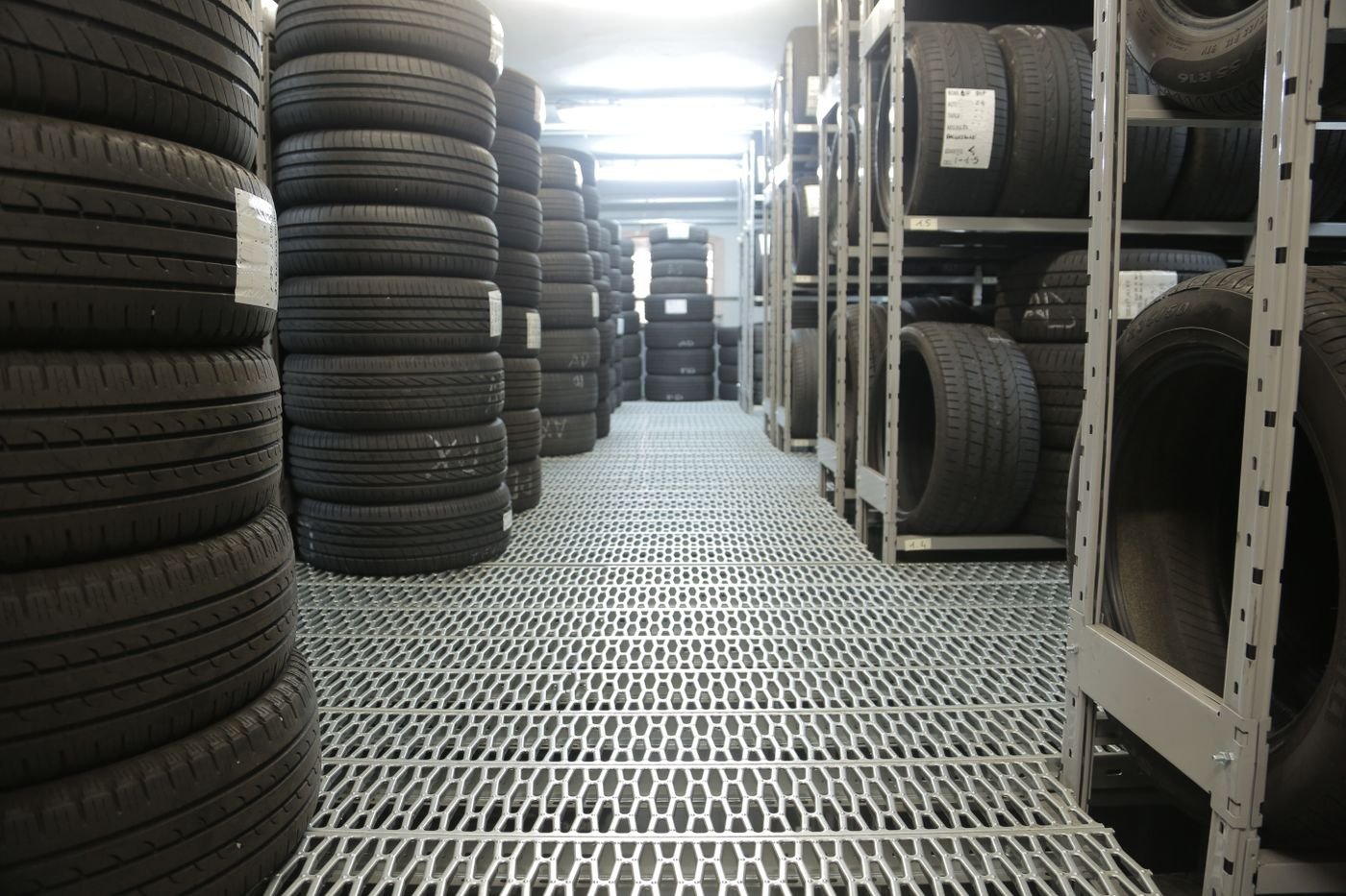 Representative photo of a warehouse aisle of used tires stacked on storage racks
