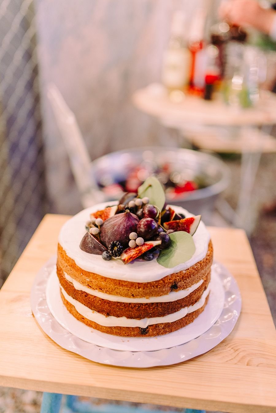 Naked celebration cake topped with fresh fruit and figs