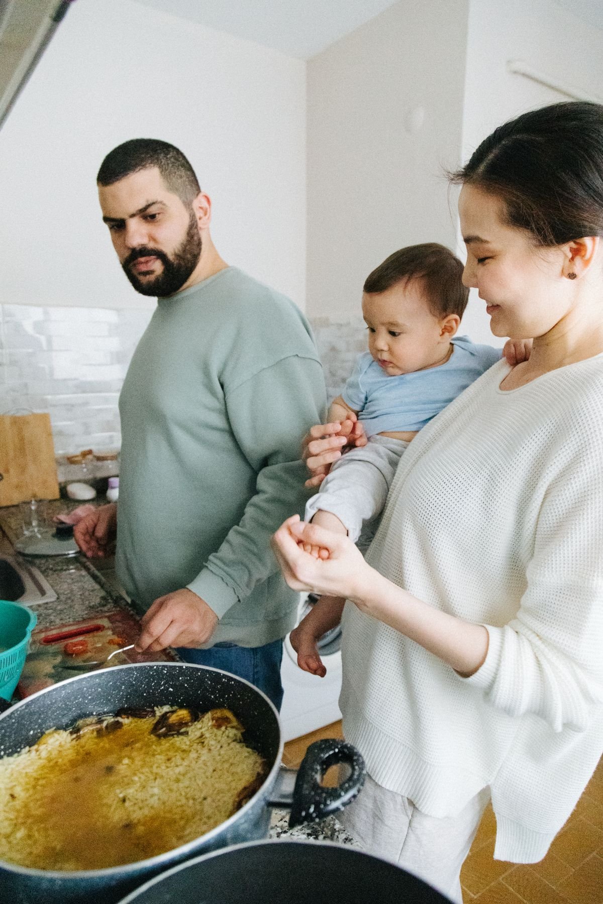 Representative photo: a family cooking together at home in the kitchen.