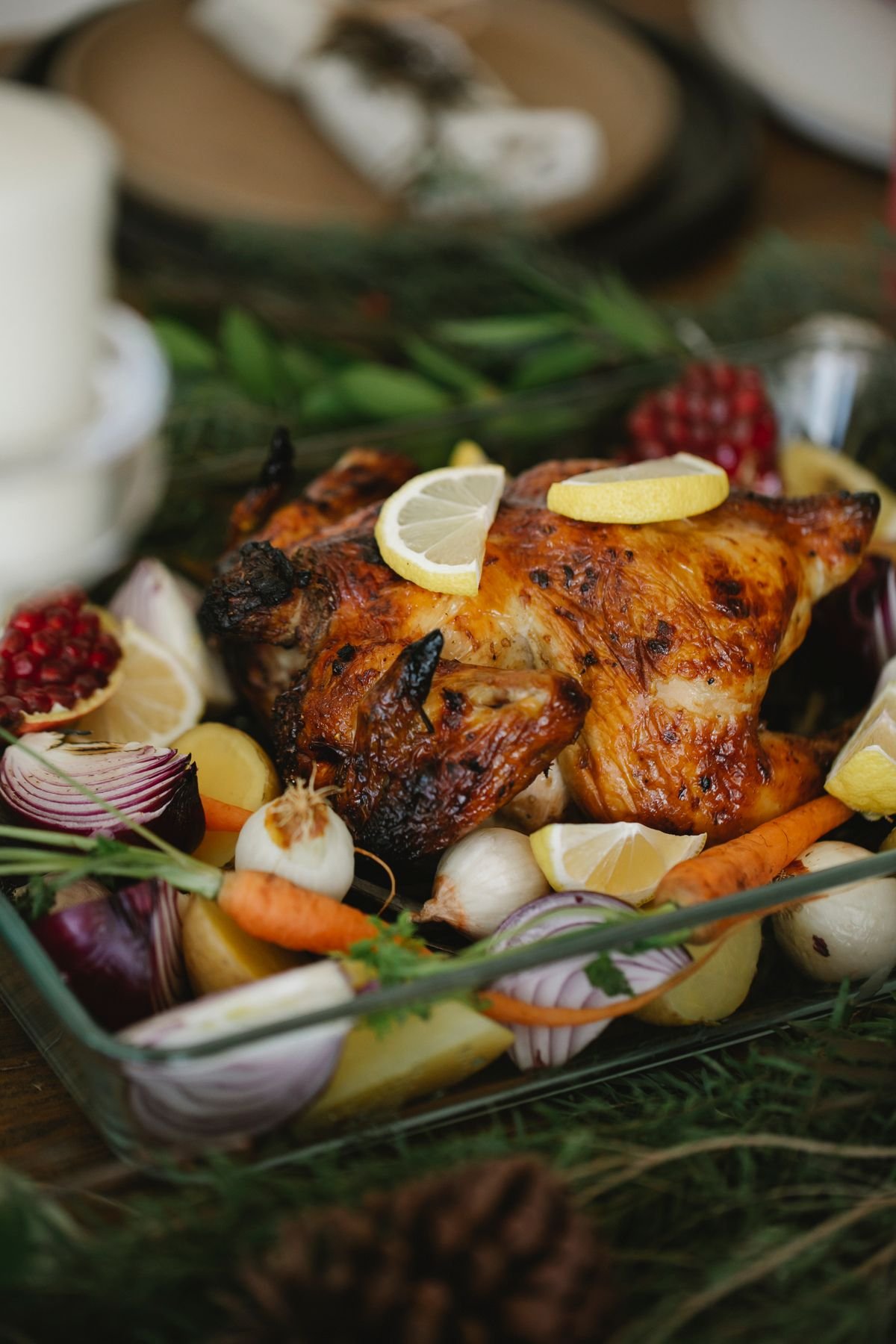 Representative photo: a roasted whole chicken with lemon and vegetables in a glass dish.