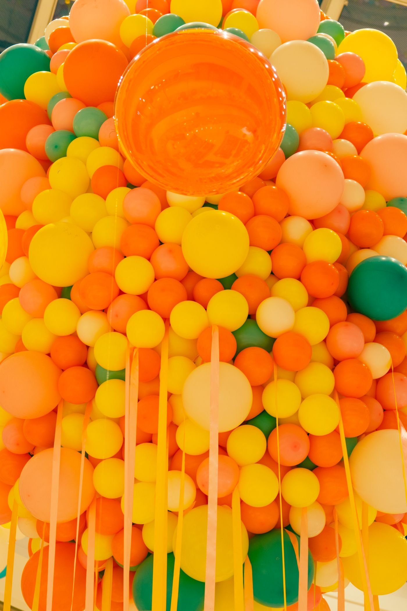 Representative photo of a wall of orange, yellow and green balloons.