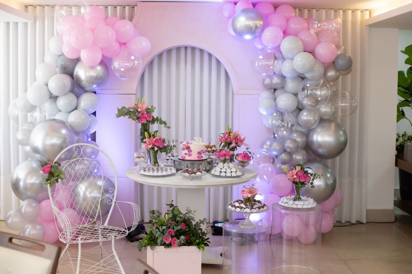 Representative photo of a decorated dessert table with a balloon garland and cake.