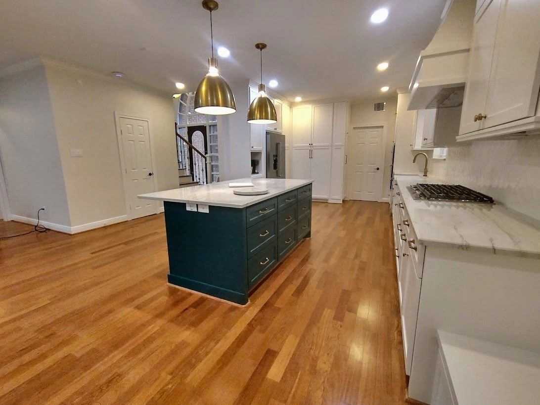 Remodeled kitchen with teal island and marble waterfall counters by Olivo Remodeling