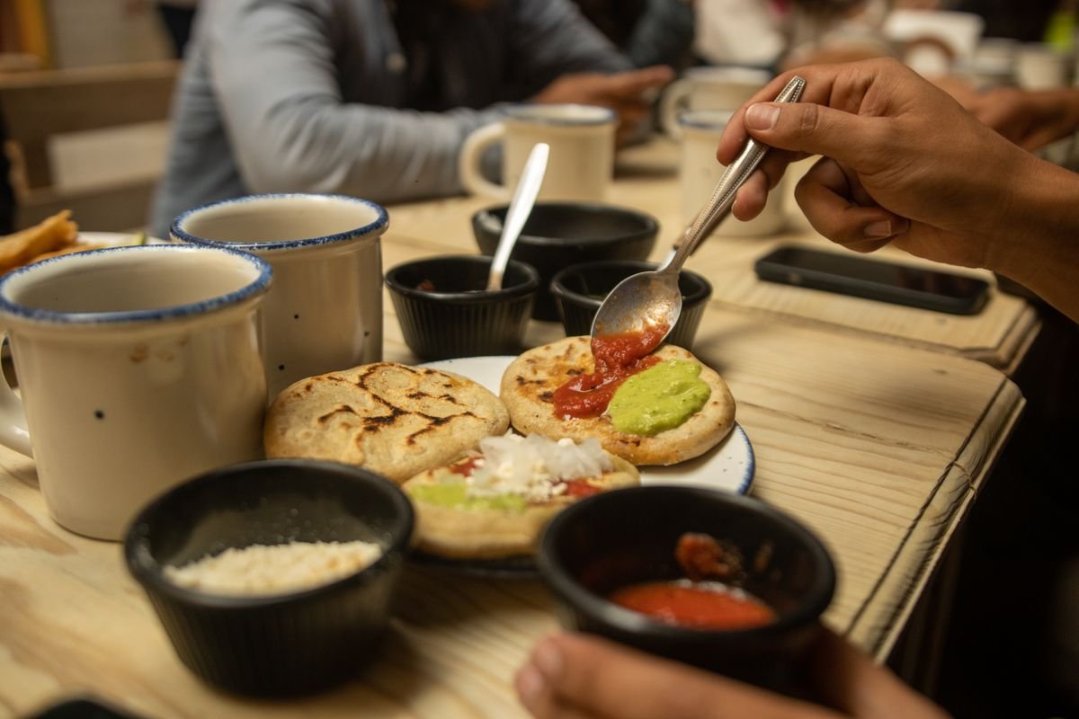 Representative photo of revueltas pupusas served with salsa and cheese