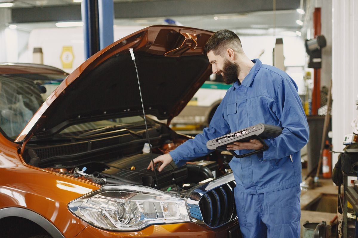 Representative photo of a technician inspecting a vehicle to prepare a repair estimate