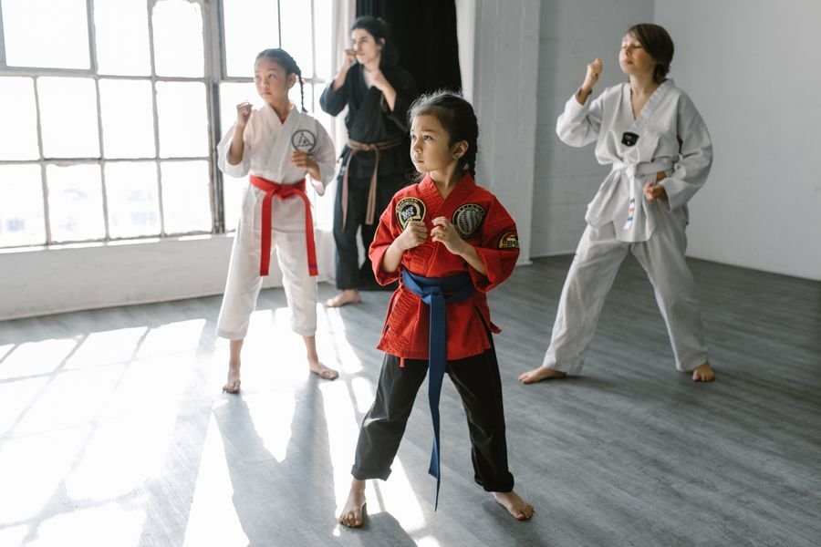 Representative photo of children in karate uniforms practicing stances in a class with an instructor